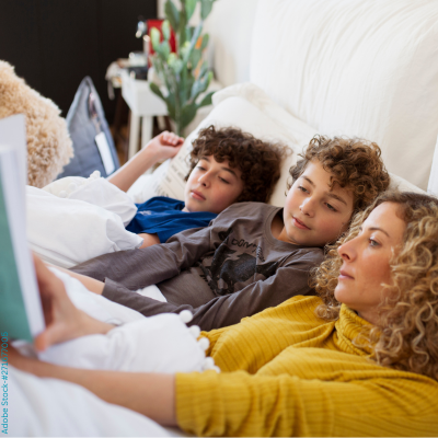 Mutter mit Ihren zwei Kindern entspannen sich beim Buch lesen